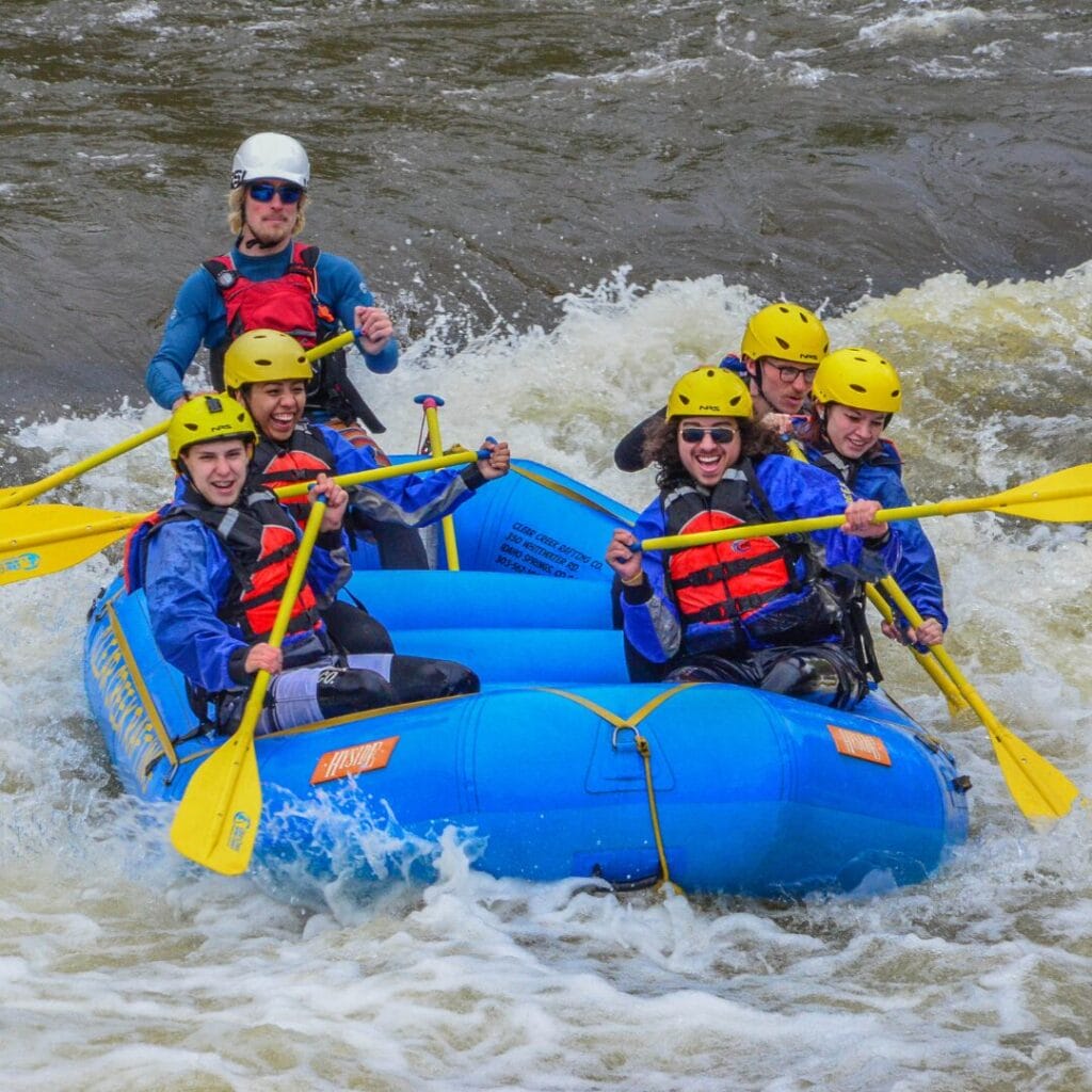 Kids and teacher in a river in a raft