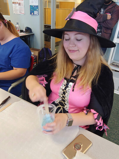 Costumed girl doing experiment in fall festival