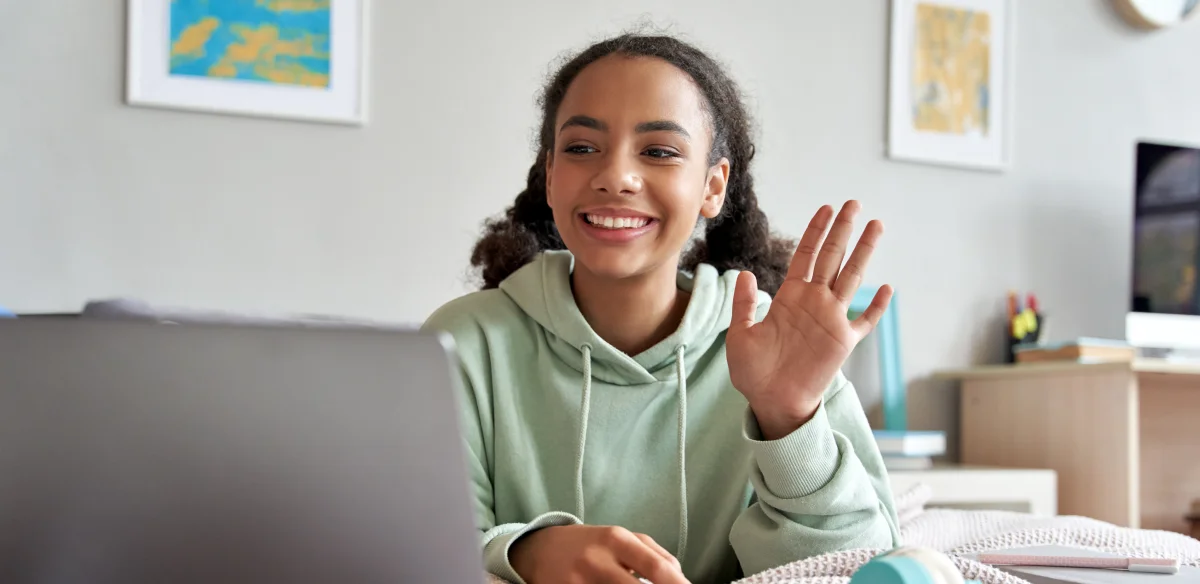 High school student attending to an online class wearing a light green hoodie